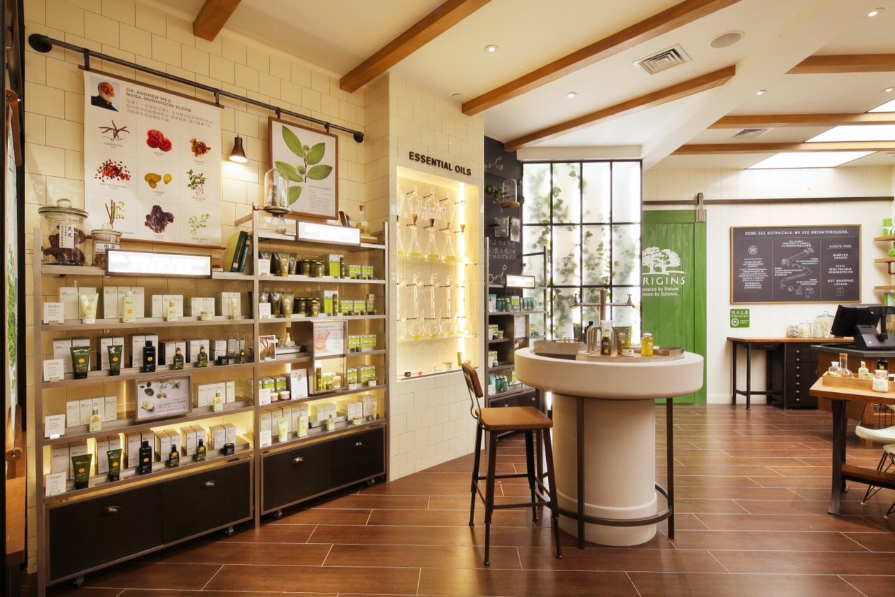 Interior of a store showcasing essential oils and botanical products with shelves filled with small bottles and boxes, a chalkboard menu, and a green door.