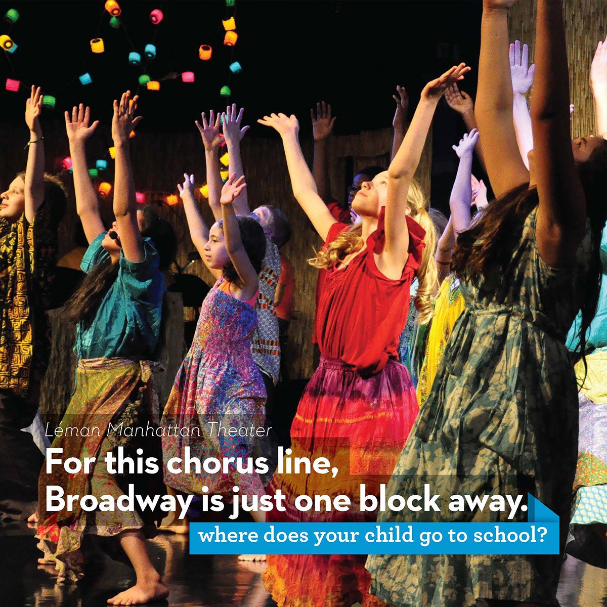 Children performing on stage with colorful costumes, raising their arms, with stage lights and hanging lanterns in the background.